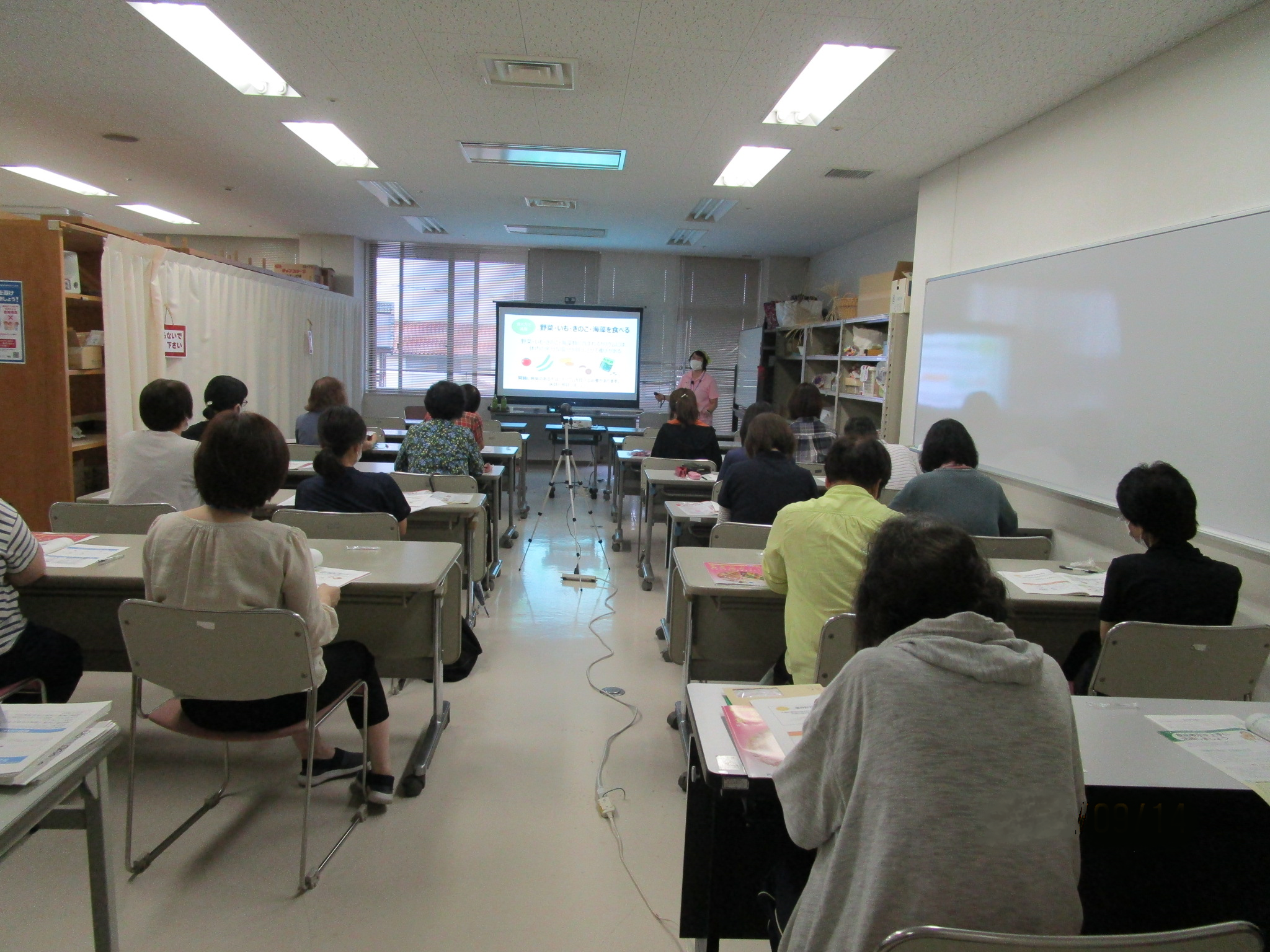 20名近いヘルパーが勉強のため講義を受けている写真