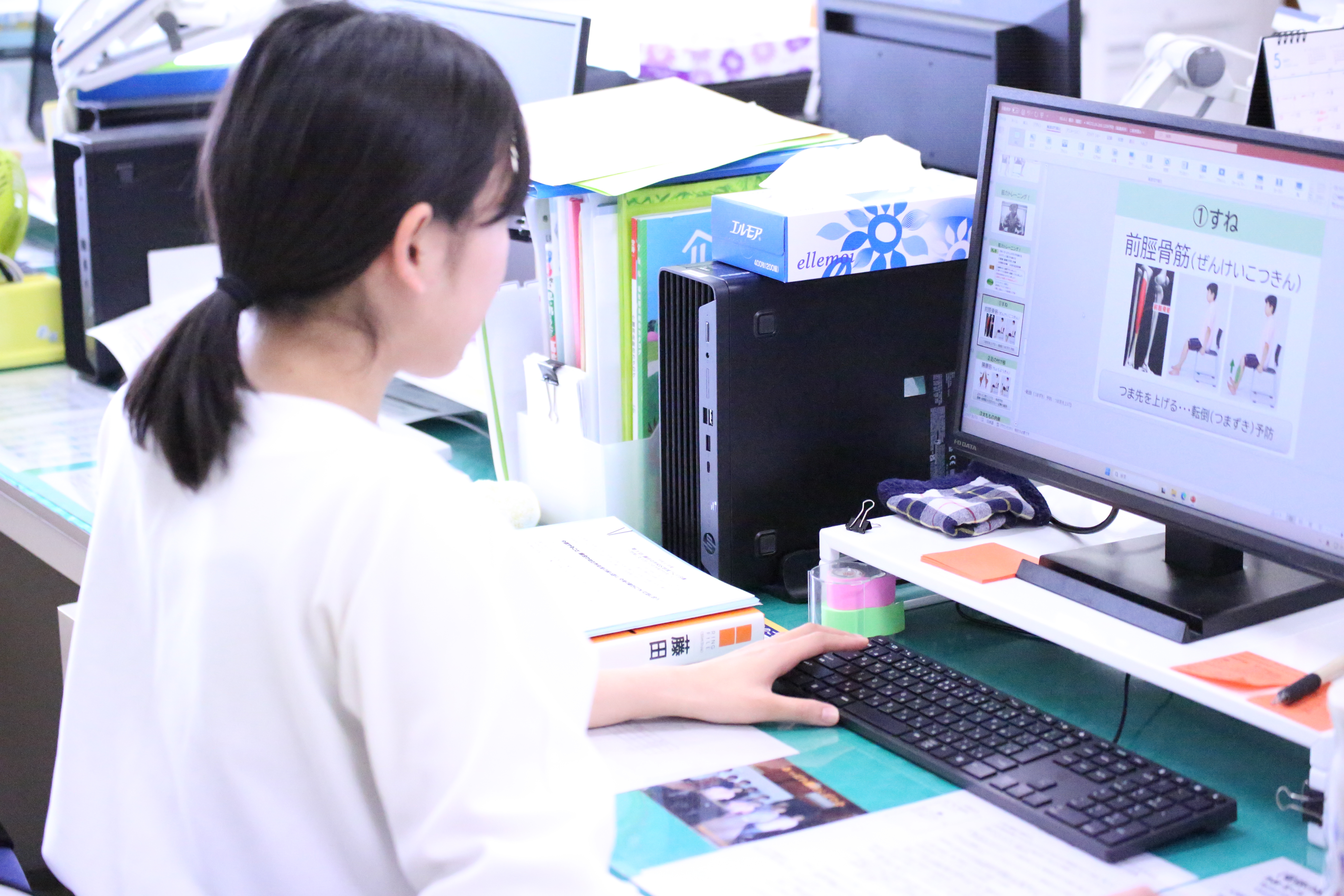 事務所で教室で使用する資料を作る様子